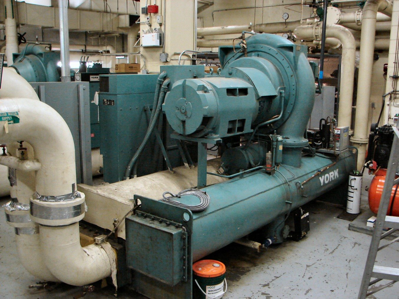 A large industrial chiller unit with pipework in a plant room.